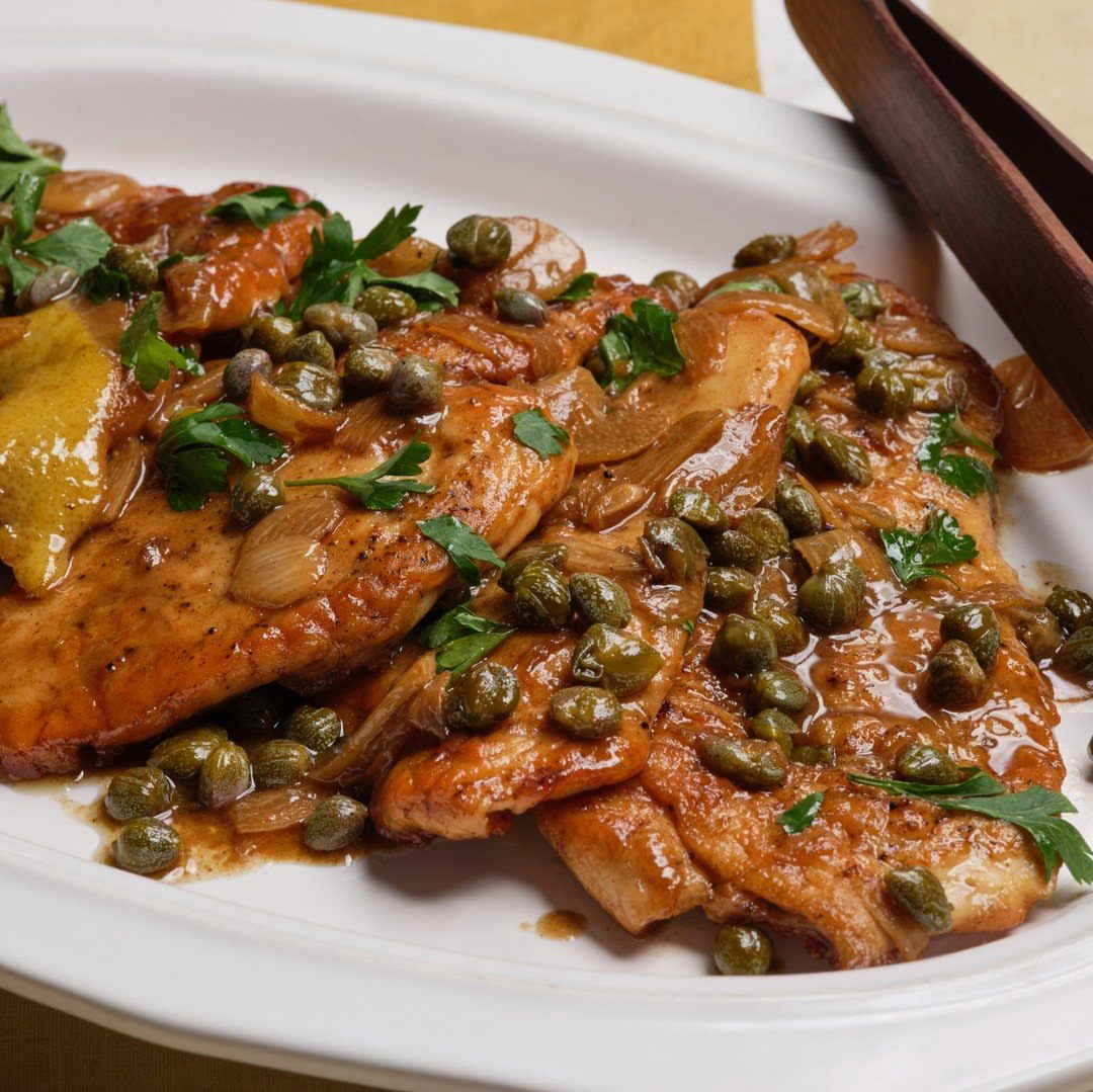 Chicken breasts topped with capers and parsley in a lemon butter sauce
