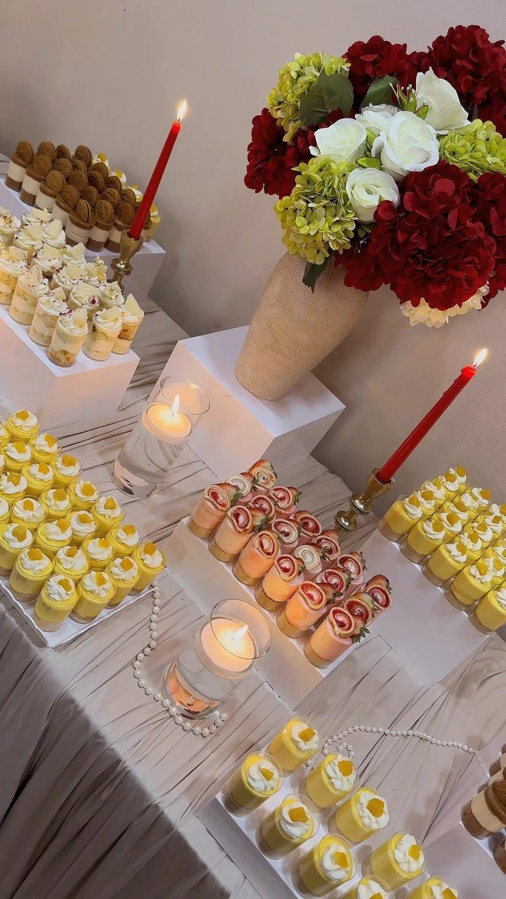 Mini dessert shooters with cream and fruit on a decorated wedding dessert table.