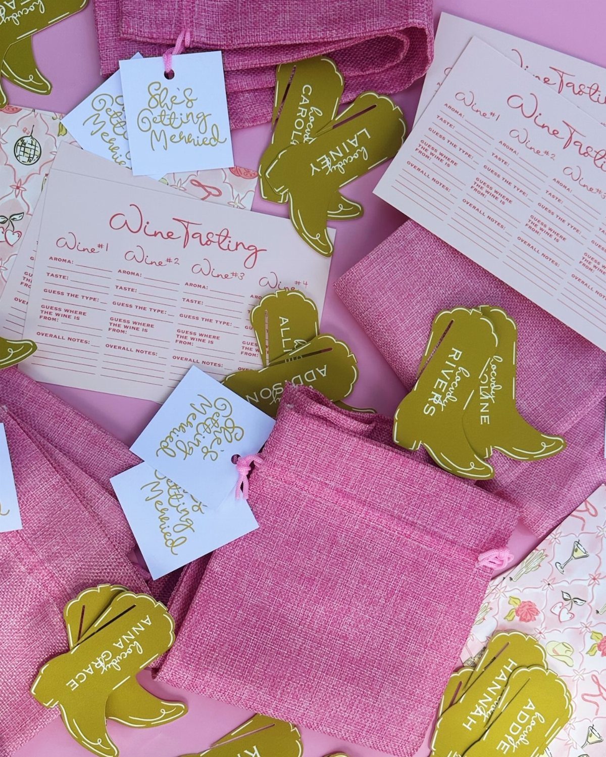 Wine tasting scorecards and pink gift pouches with gold shoe-shaped name tags.