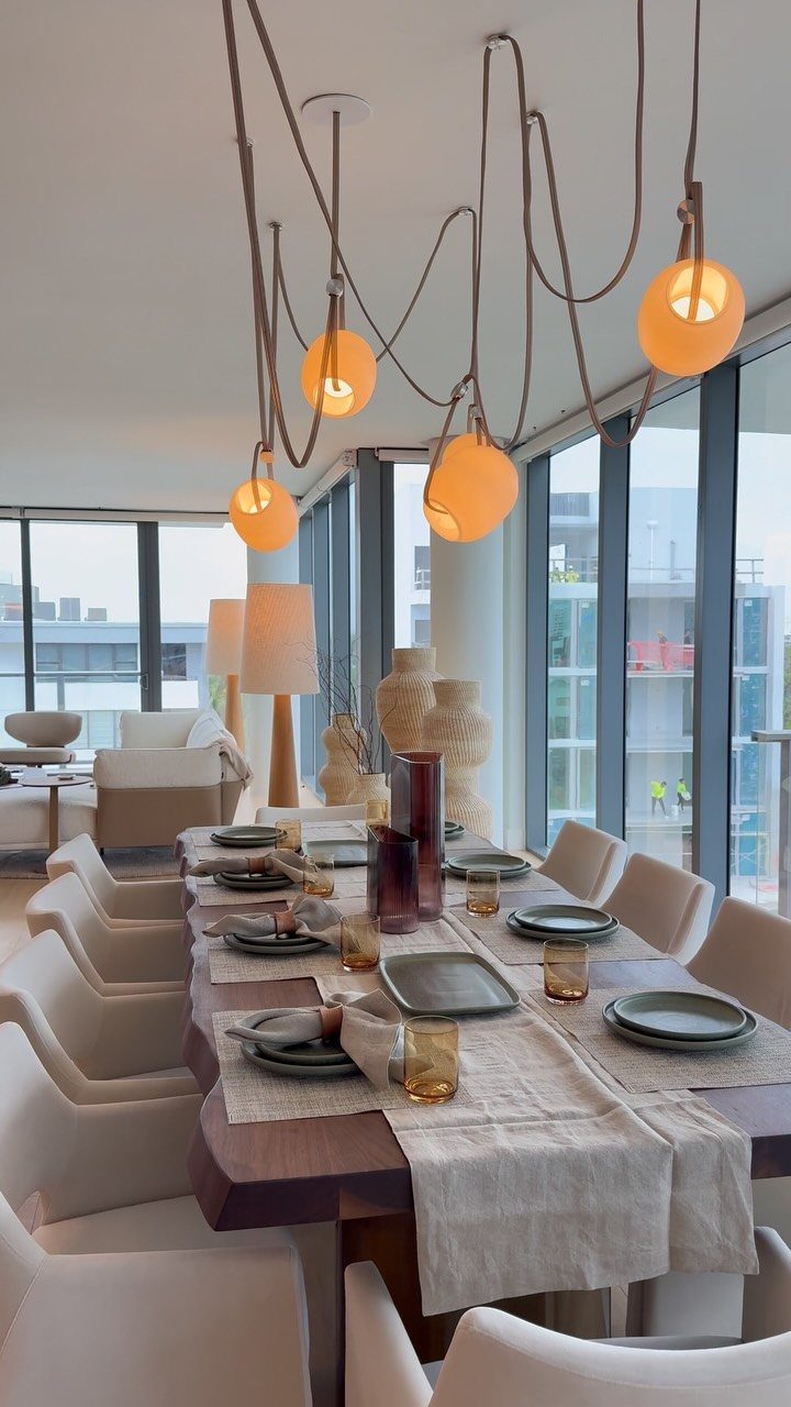 Dark wood dining table set with grey plates and beige linens in modern room